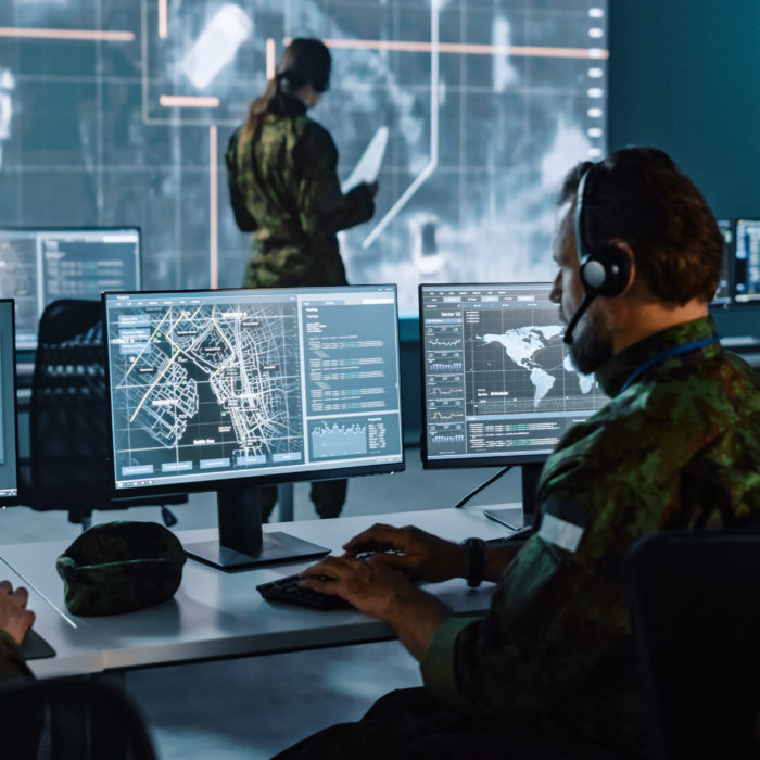 Military Surveillance Officer Working on a City Tracking Operation in a Central Office Hub for Cyber Control and Monitoring for Managing National Security, Technology and Army Communications.