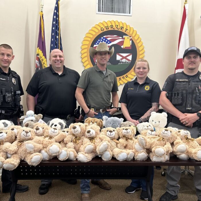 Gurley Alabama police officers stand with MartinFed's donation of Teddy Bears